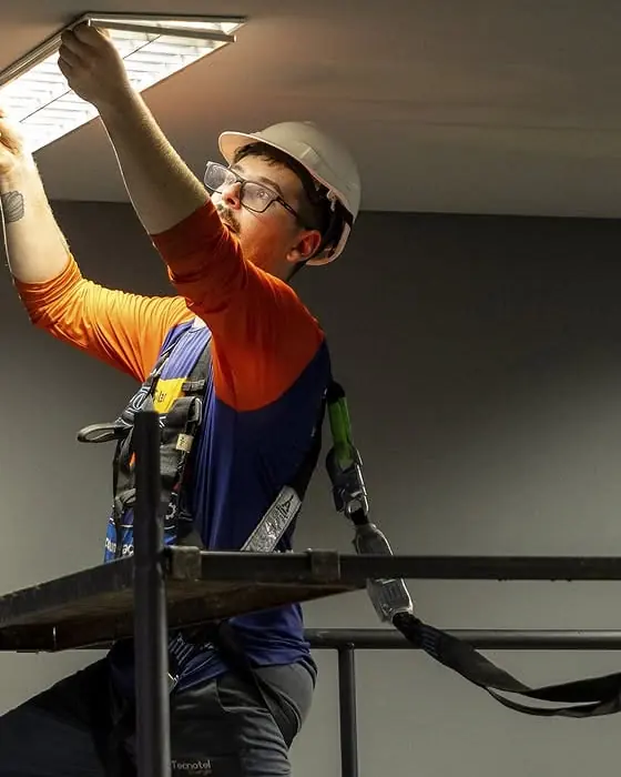 Técnico da Tecnotel executando instalação elétrica com equipamento de proteção