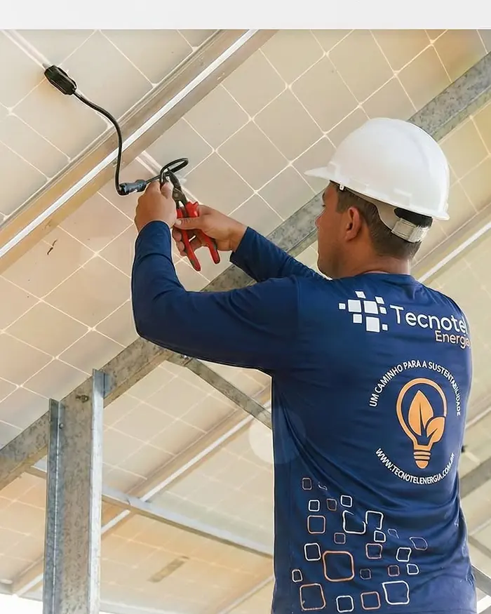 Técnico da Tecnotel trabalhando sob módulos fotovoltaicos